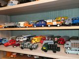 de nombreux camions miniatures posés sur une étagère dans une pièce
