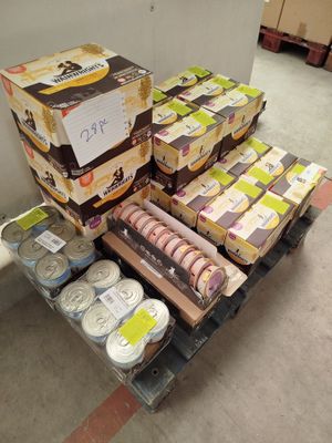 Des cartons de denrées alimentaires sont empilés sur une palette dans un entrepôt