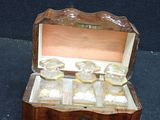 a small wooden box that has a bunch of glass items inside of it