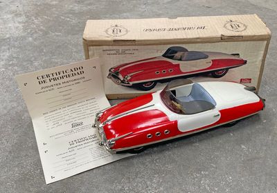 une petite voiture rouge et blanche posée devant une boîte