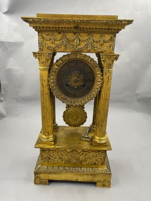 l'image d'une horloge en or posée sur une table