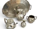 silver plated tea set with teapots, cups, and saucer