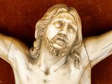 a statue of jesus on the cross with his hands up