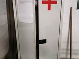un réfrigérateur blanc orné d'une croix rouge, dans un garage