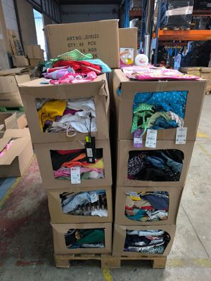 Des cartons de vêtements sont empilés les uns sur les autres dans un entrepôt
