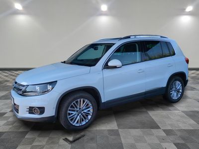 a white volkswagen tigua is parked in a large room