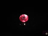 un gros plan sur un diamant rouge dans l'obscurité