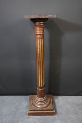 an image of a wooden pedestal with a marble top on a gray surface