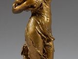 statue en bronze représentant une femme tenant un bébé dans ses bras, posée sur un socle