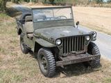a green jeep that is parked on the side of the road