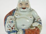 une figurine représentant un Bouddha riant, assis par terre