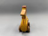 yellow wooden toy dog sitting on top of a white surface