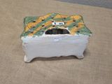a small white box with a green and yellow design on it