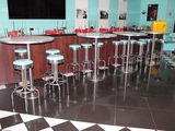 des tables et des tabourets dans un snack-bar au sol en damier