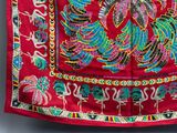 a close up of a red cloth with a bird on it