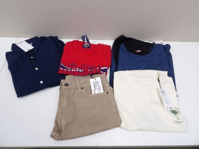 trois paires de pantalons pour homme et un polo posés sur une table