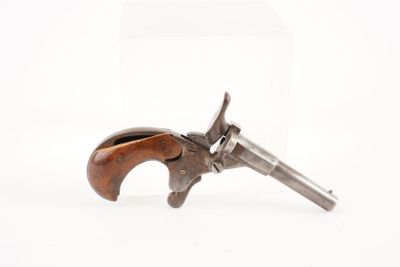 un vieux revolver avec un manche en bois sur fond blanc