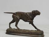 statue d'un chien en train de courir, posée sur un socle en bois, sur fond blanc