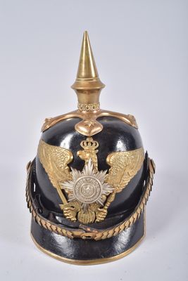 une image représentant un casque noir et doré orné d'un aigle doré