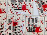 many pieces of red and black sewing supplies on a table