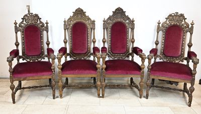 quatre chaises en velours rouge sont alignées contre un mur blanc