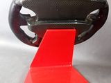 a close up of a red stand with a steering wheel on it