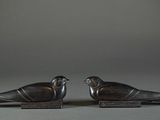 two metal birds that are sitting on top of each other