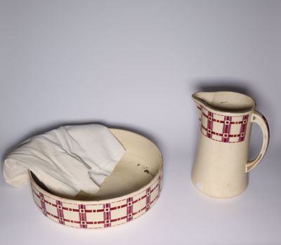 a pitcher and a bowl sitting next to each other on a table