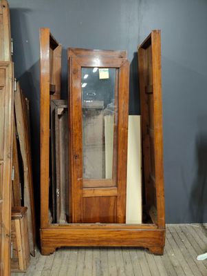 a wooden cabinet with a glass door in the middle of it