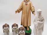 figurines représentant une femme accompagnée d'anges, ainsi que des anges, sur fond blanc