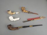 a lot of different types of smoking pipes on the table