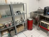 a kitchen with a sink, microwave, and other items on the shelves