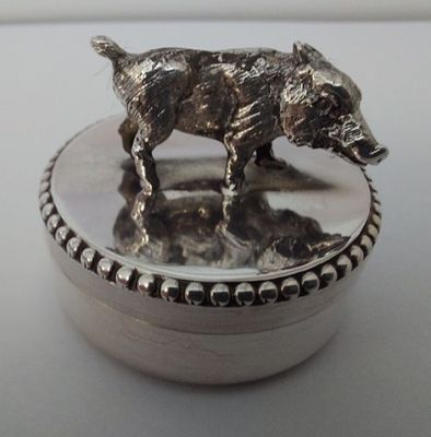 une boîte en argent ornée d'un chien, posée sur une table