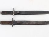 two old knives are sitting side by side on a white surface