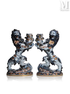 deux figurines représentant deux lions se tenant par la main, posées sur un fond blanc
