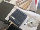 a table with a laptop, a fan, and magazines on it