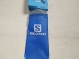 someone is holding a water bottle with a blue cover and a pair of scissors