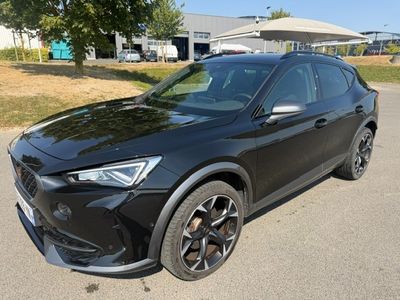 une voiture noire garée dans un parking à côté d'un bâtiment