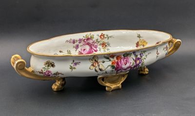 a white bowl with flowers on it sitting on a table