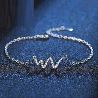 un bracelet en argent sur lequel est gravée la lettre « w »