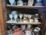 a wooden cabinet with many cups and saucers on it