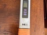 a digital thermometer on a wooden table next to a chair