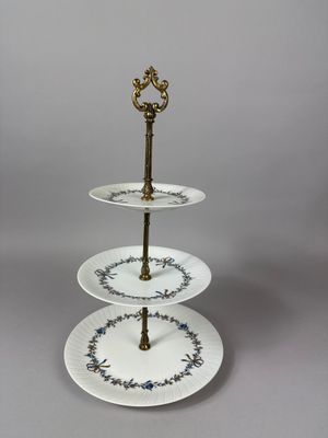 three tiered cake stand with three plates on top of it