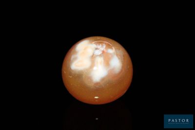 a picture of an orange ball on a black surface