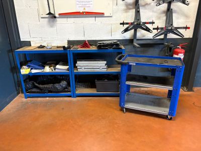a blue work bench with two shelves and a shelf with tools