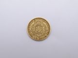 une pièce d'or sur une surface blanche