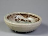 a small bowl with a fish on it on a table