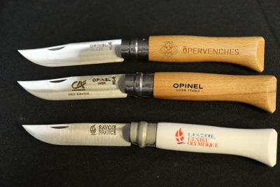 four different types of knives are lined up on a black surface
