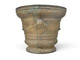 a large stone vase with a lion head on it