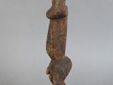 statue d'une femme debout sur un rocher, les mains sur les hanches